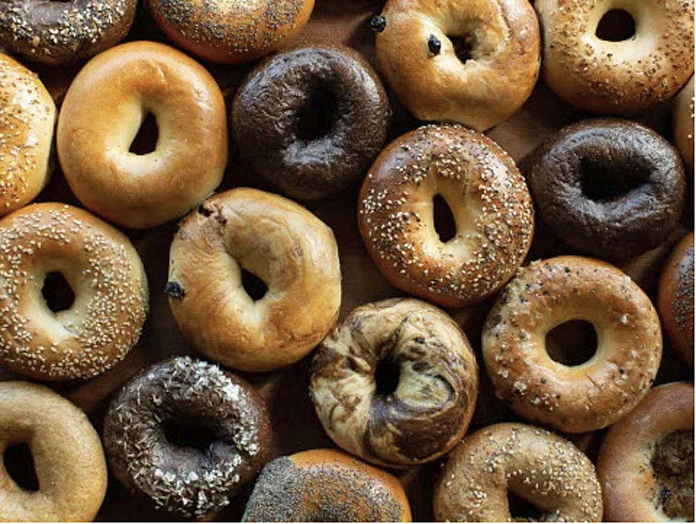 An everything bagel, dusted in flour, shot in dramatic side light